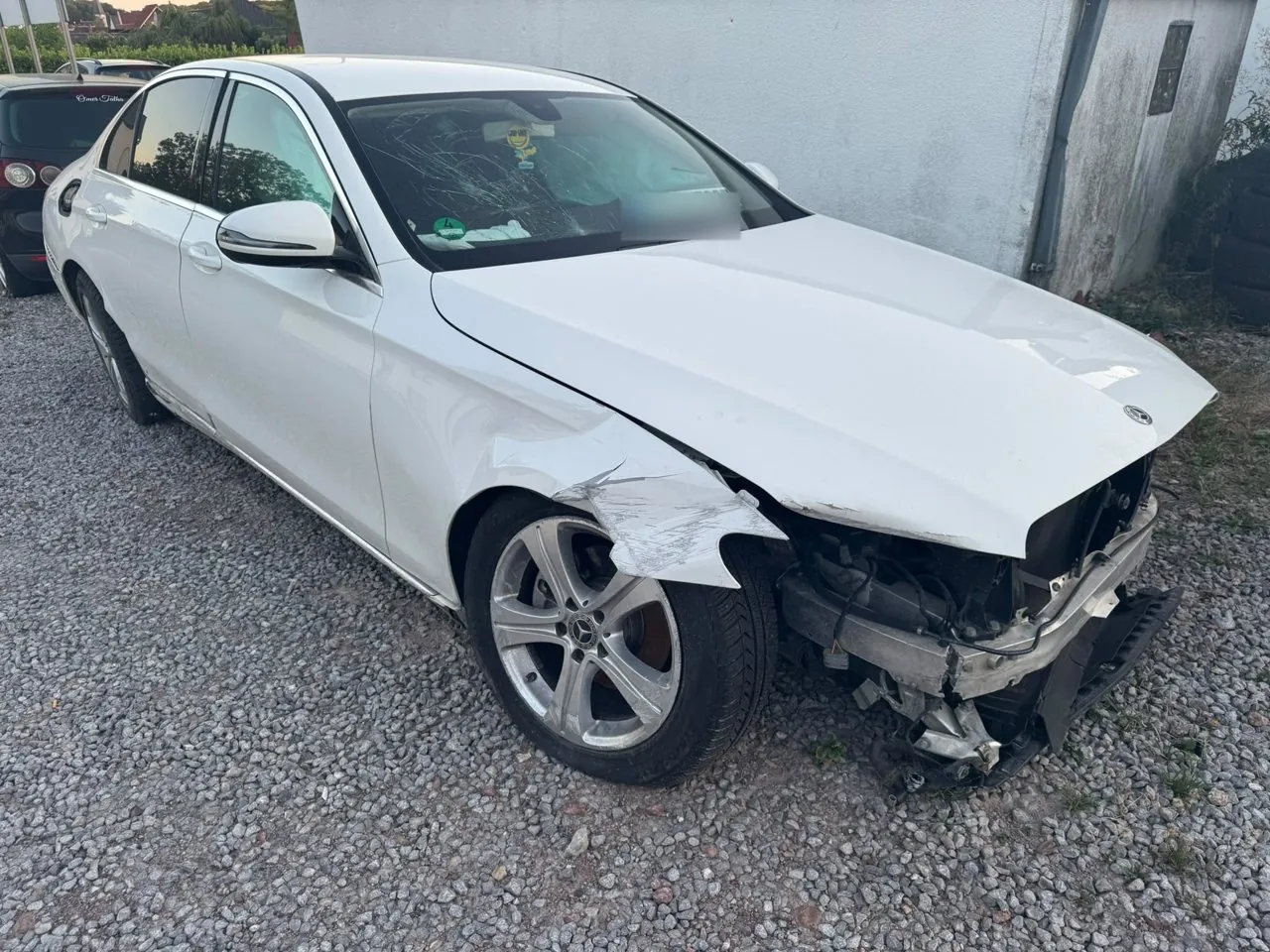 Unfallschaden an der Front eines weißen Mercedes
